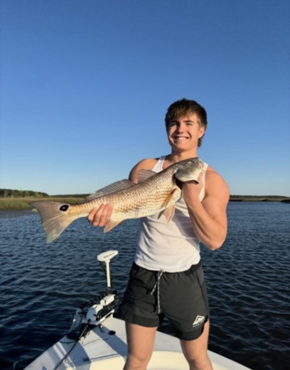 Jack holding a large redfish on a boat